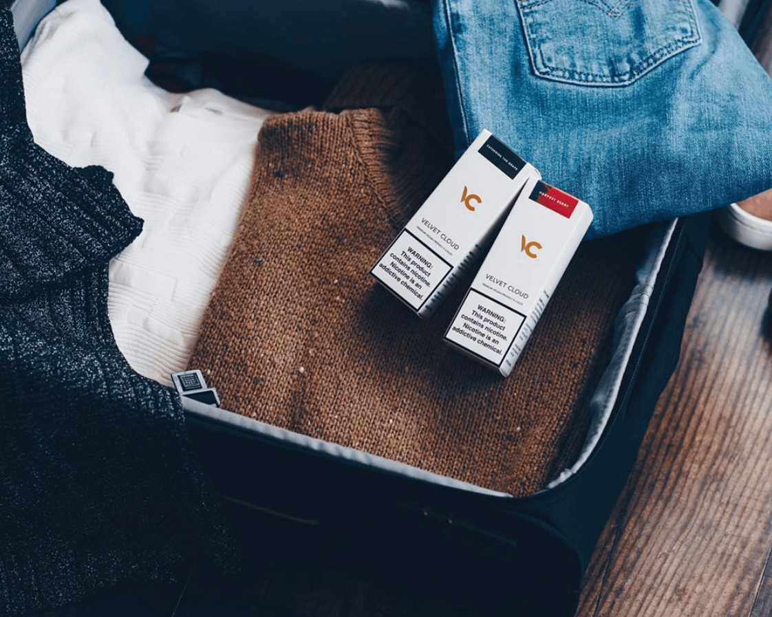 suitcase prepared for business trip or vacation with e-liquids for vaping