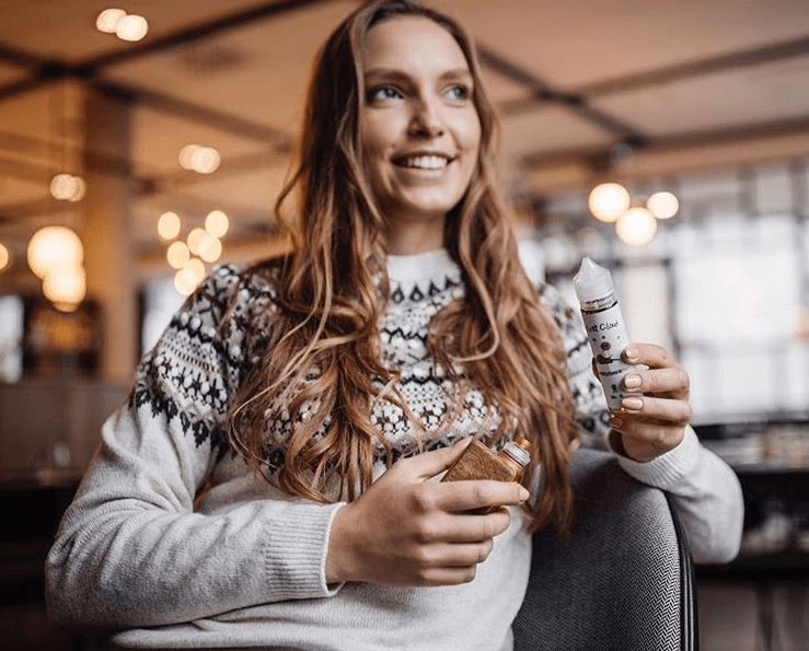 a first-time vaper holding a vape mod in one hand and velvet cloud e-liquid in the other