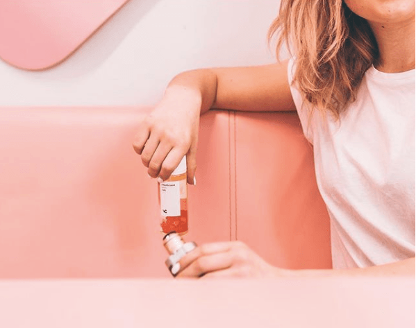 woman sitting on couch using vape