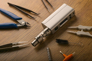 building vape pen with tweezers and pliers on table
