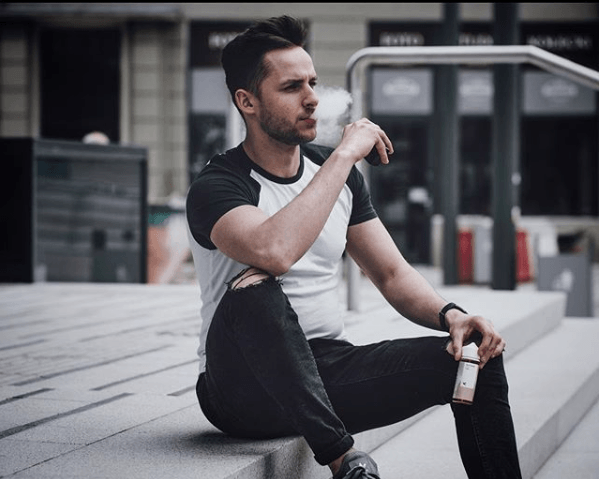 man sitting on stairs vaping