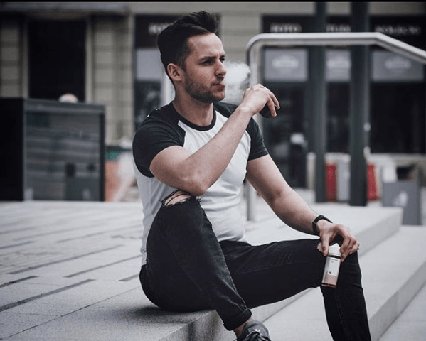 man sitting on stairs vaping