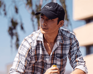 man wearing a Velvet Cloud hat holding an e-cigarette