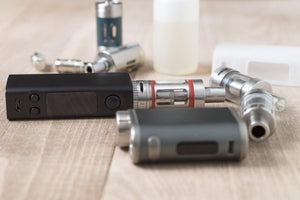 a vaping device and vaping battery on a wooden table