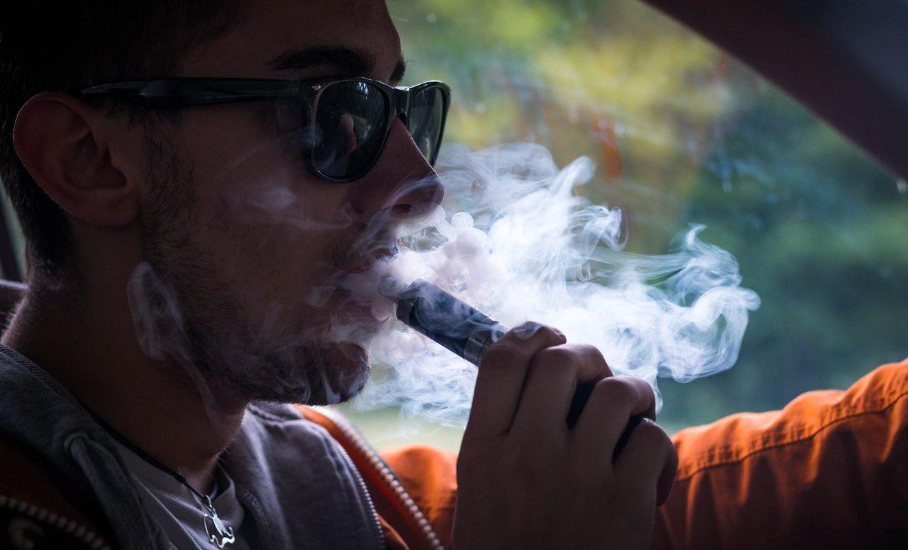 man vaping in car