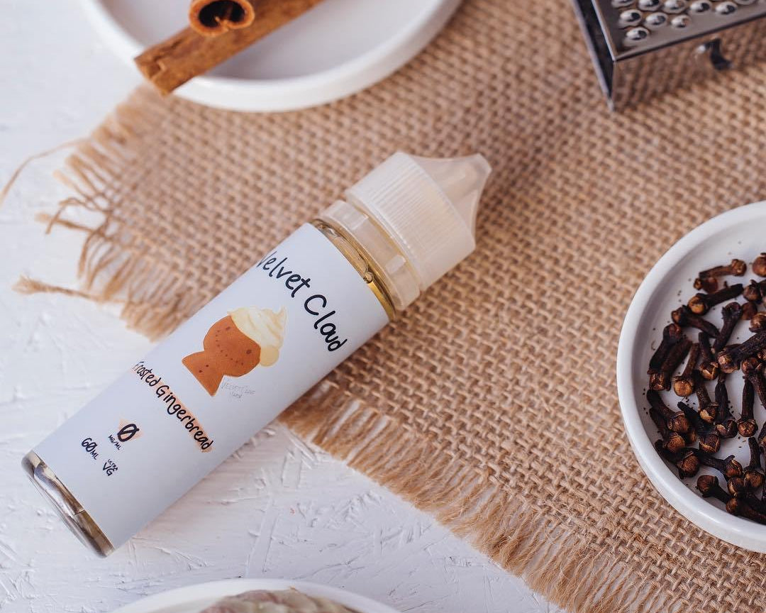 an image of Velvet Cloud's gingerbread flavored e-liquid on a table with cinnamon and other ingredients