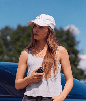 woman leaning against a car holding a Vape Mod