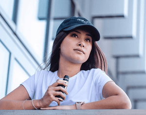 woman holding a bottle of Velvet Cloud e-liquid thinking in the mid-afternoon