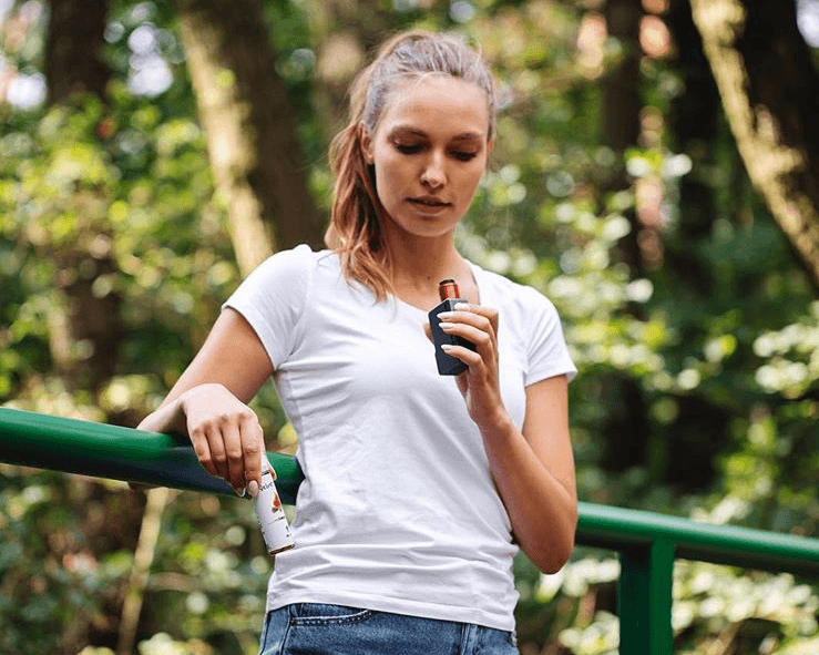 a beginner to vaping holding a vape pen and Velvet Cloud e-liquid outdoors