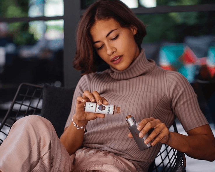 woman using Velvet Cloud e-liquid with her vaping mod